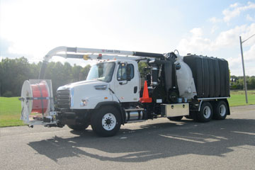 Front left side view of lawge white truck with equipment