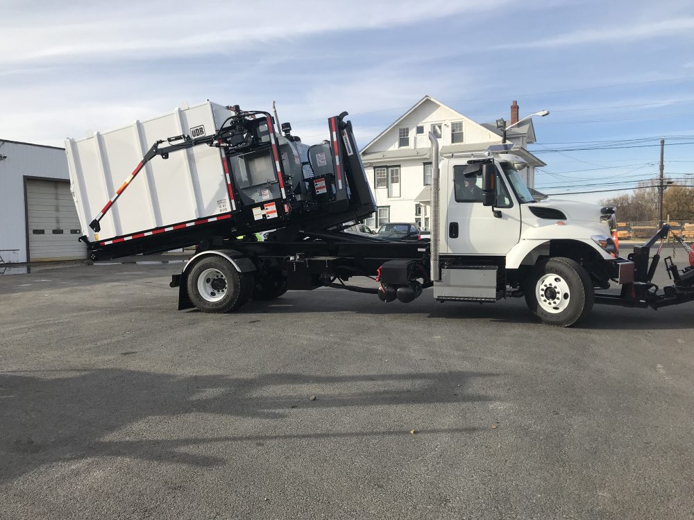 Right Side view of white hooklift truck in parking lot